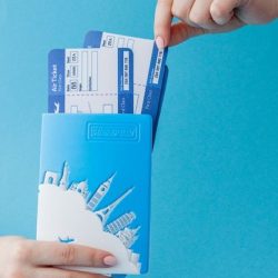 Premium Photo _ Passport and air ticket in woman hand on a blue background_ Travel concept, copy space