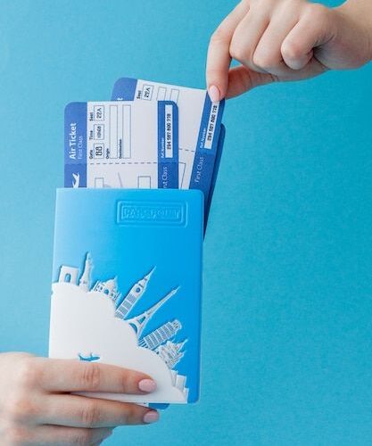 Premium Photo _ Passport and air ticket in woman hand on a blue background_ Travel concept, copy space